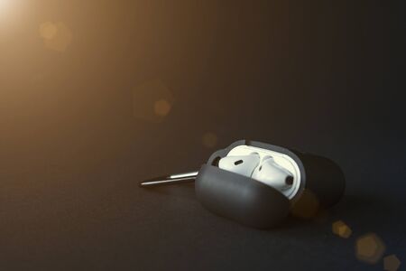 Wireless headphones in a case on a black backgroundの写真素材