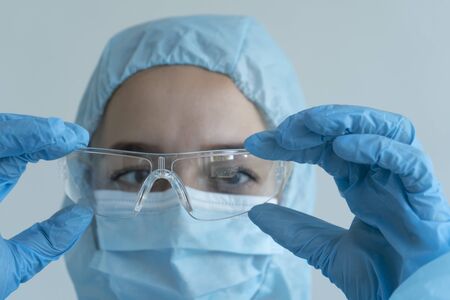 Doctor puts on goggles, covid19の写真素材