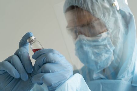 Doctor holds an ampoule with medicine