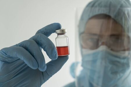 Doctor holds an ampoule with medicineの写真素材