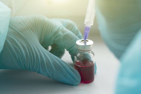 Development of a vaccine, the doctor holds an ampoule in his handの写真素材