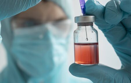Development of a vaccine, the doctor holds an ampoule in his handの写真素材