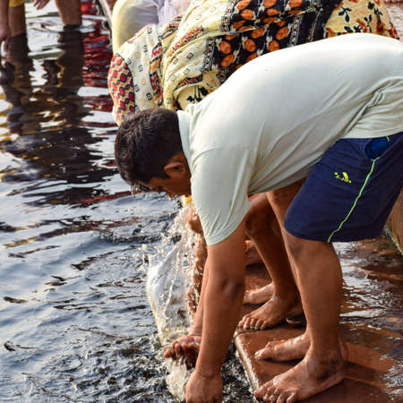 Delhi, India - Dec 31, 2019 : Man taking bath in holy river of Yamuna during morning time in Delhi India, People taking holy dip inside Yamuna riverのeditorial素材