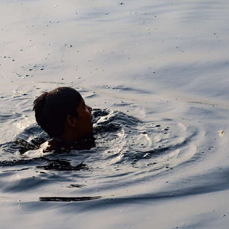 Delhi, India - Dec 31, 2019 : Man taking bath in holy river of Yamuna during morning time in Delhi India, People taking holy dip inside Yamuna riverのeditorial素材