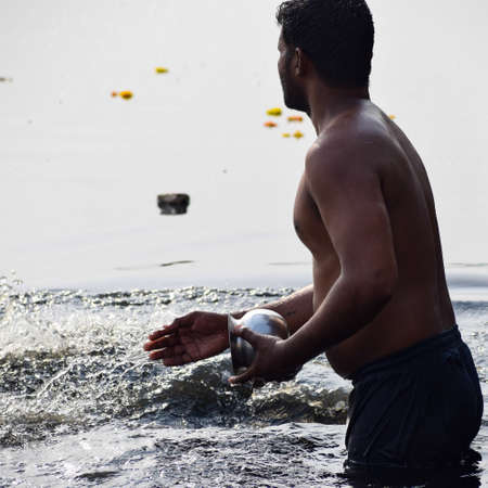 Delhi, India - Dec 31, 2019 : Man taking bath in holy river of Yamuna during morning time in Delhi India, People taking holy dip inside Yamuna riverのeditorial素材