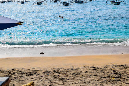 Picturesque ocean cove of Crystal Bay at sunset. Crashing waves, anchored boats, colorful sunset,...