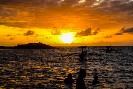 Picturesque ocean cove of Crystal Bay at sunset. Crashing waves, anchored boats, colorful sunset,...