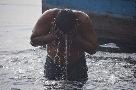 Delhi, India - Dec 31, 2019 : Man taking bath in holy river of Yamuna during morning time in Delhi...
