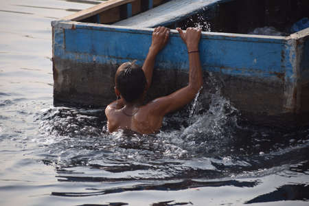 Delhi, India - Dec 31, 2019 : Man taking bath in holy river of Yamuna during morning time in Delhi India, People taking holy dip inside Yamuna riverのeditorial素材
