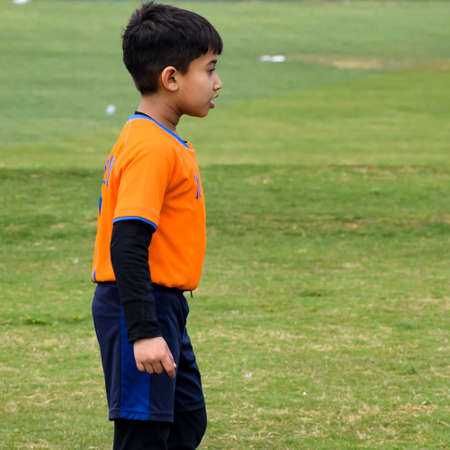 New Delhi, India - January 26 2020: Footballers of local football team during game in regional Derby championship on a bad football pitch. Hot moment of football match on grass green field of the stadiumのeditorial素材