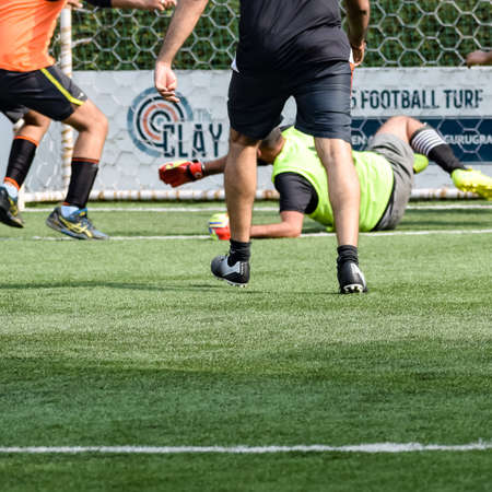 New Delhi, India - July 19 2019: Footballers of local football team during game in regional Derby championship on a bad football pitch. Hot moment of football match on grass green field of the stadiumのeditorial素材