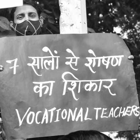 Delhi, India December 25 2021 : Delhi Contractual Guest Teachers with posters, flags and graffitiâs protesting against Delhi AAP Government for making policy, Delhi Teacher protesting Black and Whiteのeditorial素材