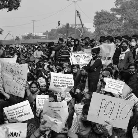 Delhi, India December 25 2021 : Delhi Contractual Guest Teachers with posters, flags and graffitiâs protesting against Delhi AAP Government for making policy, Delhi Teacher protesting Black and Whiteのeditorial素材