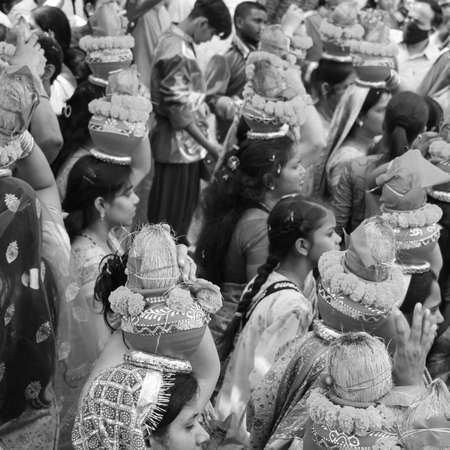 Delhi, India April 03 2022 - Women with Kalash on head during Jagannath Temple Mangal Kalash Yatra, Indian Hindu devotees carry earthen pots containing sacred water with coconut on top Black and Whiteのeditorial素材