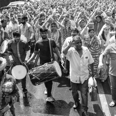 Delhi, India April 03 2022 - Women with Kalash on head during Jagannath Temple Mangal Kalash Yatra, Indian Hindu devotees carry earthen pots containing sacred water with coconut on top Black and Whiteのeditorial素材