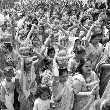 Delhi, India April 03 2022 - Women with Kalash on head during Jagannath Temple Mangal Kalash Yatra, Indian Hindu devotees carry earthen pots containing sacred water with coconut on top-Black and Whiteのeditorial素材