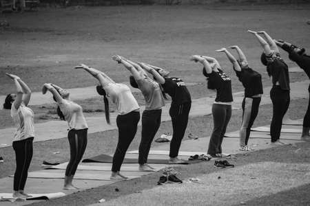 New Delhi, India, June 18 2022 â Group Yoga exercise class for people of different age in Lodhi Garden Park. International Day of Yoga, Big group of adult attending yoga class in park -Black and Whiteのeditorial素材