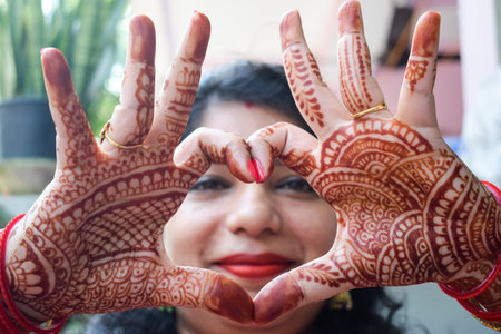Beautiful woman dressed up as Indian tradition with henna mehndi design on her both hands to celebrate big festival of Karwa Chauth, Karwa Chauth celebrations by Indian woman for her husbandの写真素材