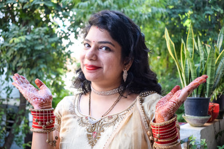 Beautiful woman dressed up as Indian tradition with henna mehndi design on her both hands to celebrate big festival of Karwa Chauth, Karwa Chauth celebrations by Indian woman for her husbandの写真素材