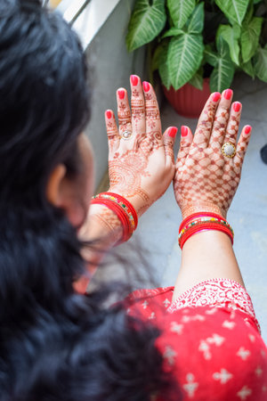 Beautiful woman dressed up as Indian tradition with henna mehndi design on her both hands to celebrate big festival of Karwa Chauth, Karwa Chauth celebrations by Indian woman for her husbandの写真素材