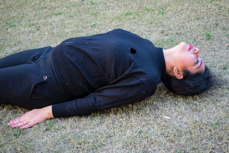 Young Indian woman practicing yoga outdoor in a park. Beautiful girl practice basic yoga pose....