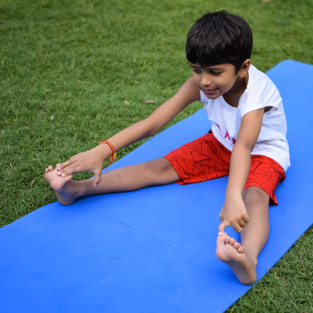 Asian smart kid doing yoga pose in the society park outdoor, Children's yoga pose. The little boy doing Yoga exerciseの写真素材