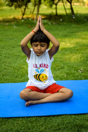 Asian smart kid doing yoga pose in the society park outdoor, Children's yoga pose. The little boy doing Yoga exerciseの写真素材
