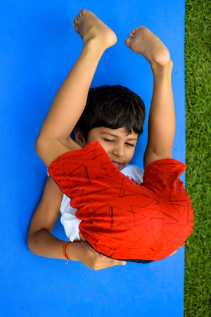 Asian smart kid doing yoga pose in the society park outdoor, Children's yoga pose. The little boy...