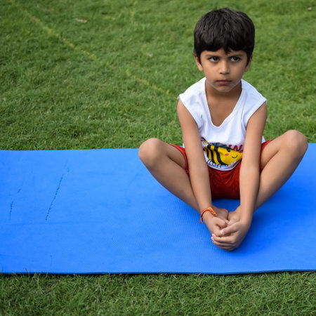 Asian smart kid doing yoga pose in the society park outdoor, Children's yoga pose. The little boy doing Yoga and meditation exercise.の写真素材