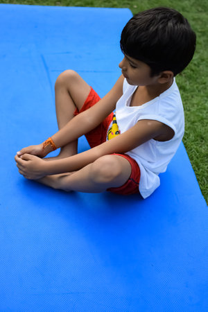 Asian smart kid doing yoga pose in the society park outdoor, Children's yoga pose. The little boy doing Yoga and meditation exercise.の写真素材