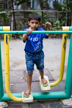 Asian boy doing routine exercise in society park during the morning time. Cute little kid exercise and gym to keep himself fit for life. Child's exercise outdoor shootの写真素材