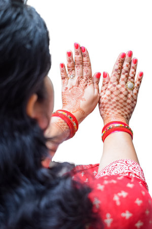 Beautiful woman dressed up as Indian tradition with henna mehndi design on her both hands to celebrate big festival of Karwa Chauth with plain white backgroundの写真素材