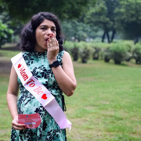 A pregnant Indian lady poses for outdoor pregnancy shoot and hands on belly, Indian pregnant woman...