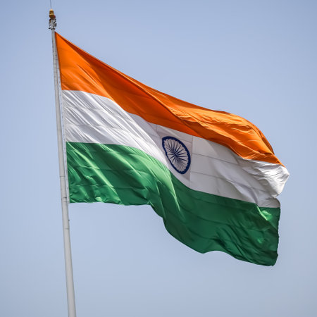India flag flying high at Connaught Place with pride in blue sky, India flag fluttering, Indian Flag on Independence Day and Republic Day of India, tilt up shot, Waving Indian flag, Har Ghar Tirangaの写真素材