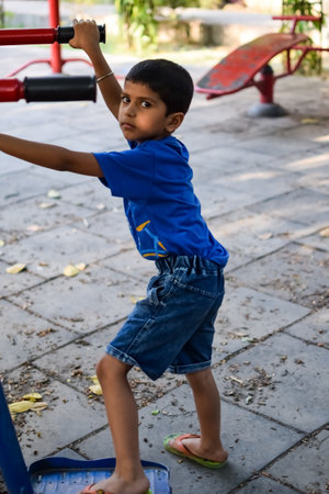 Asian boy doing routine exercise in society park during the morning time. Cute little kid exercise and gym to keep himself fit for life. Child exercise outdoor shootの写真素材