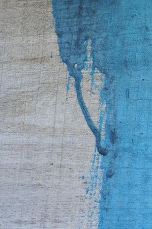 Wooden board painted half with blue paint. Abstract background. Blue paint drip.の写真素材