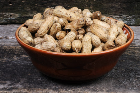 Peanuts in a bowl on a wooden background. Close-up.