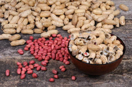 Peanuts in a bowl and peanuts in a bowl on wooden background.