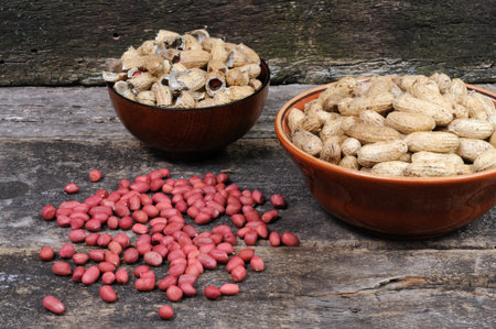 Peanuts in a bowl and peanuts in a bowl on wooden background