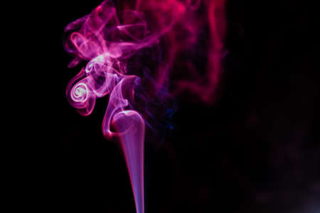 random shapes of colored smoke fired with colored flashの写真素材