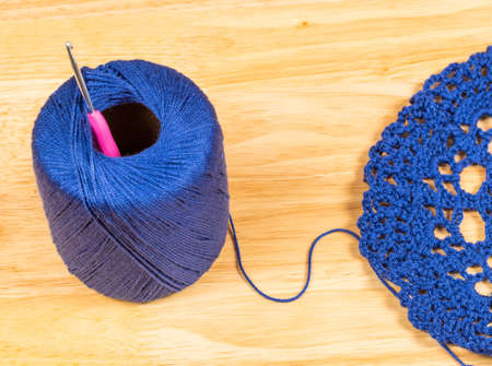Crochet piece made of wool and knitted by hand, blue wool bud detail with pink crochet hook