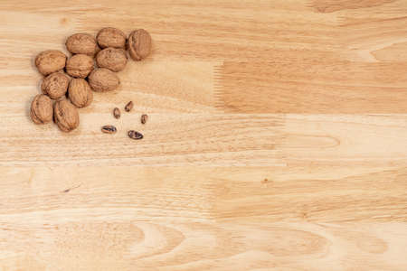 Top view of walnuts and pine nuts with copyspace on a wooden table, composition