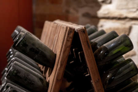 old, dusty wine bottles aging upside down in a wine cellar