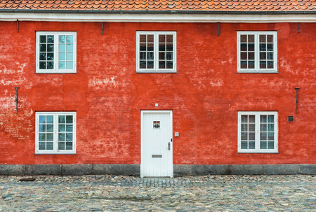 house; red; old; door; windows; six; white; bricks; copenhagen; denmark; stones; street; ancient; scandinavia; danish; typical; building; roof; orange; tiles; scratched; wall; cracked; scandinavian; northern; europe; city; town; famous; barracks;の写真素材