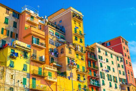 Colored houses with blue sky on the background. Clothes drying on the rope. Residential block of flats, Italyの写真素材