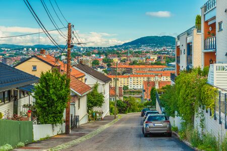 A street in Oslo, Norway. Beautiful view from a hill with old wooden houses to the city center with colorful architectureの写真素材