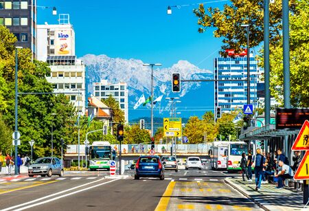 Ljubljana - September 2019, Slovenia: View of the main street with car traffic and beautiful snowy Alps in the backgroundのeditorial素材