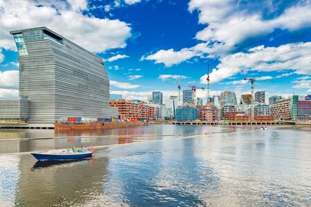 Cityscape of downtown Oslo with modern architecture, boat with a group of people and the blue sky with clouds, Norwayの写真素材