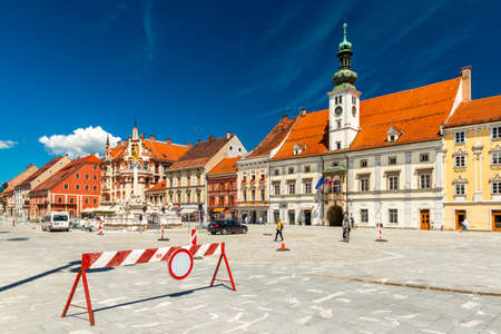 Maribor - June 2020, Slovenia: View of the main square of Maribor, Town Hall, old historical buildings, walking people, and a stop barrierのeditorial素材