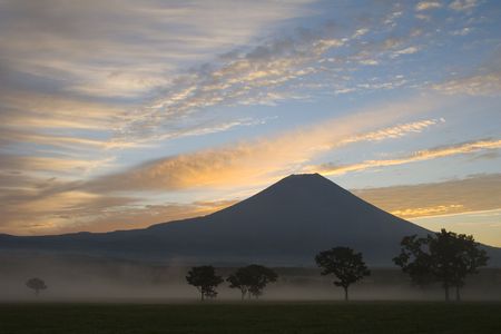 Sunrise with mist and trees over Mount Fujiの写真素材